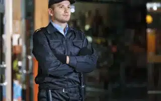 How to Choose the Right Concierge Security Team for Your Office Building – A uniformed security guard stands with arms crossed, providing a professional and attentive presence.