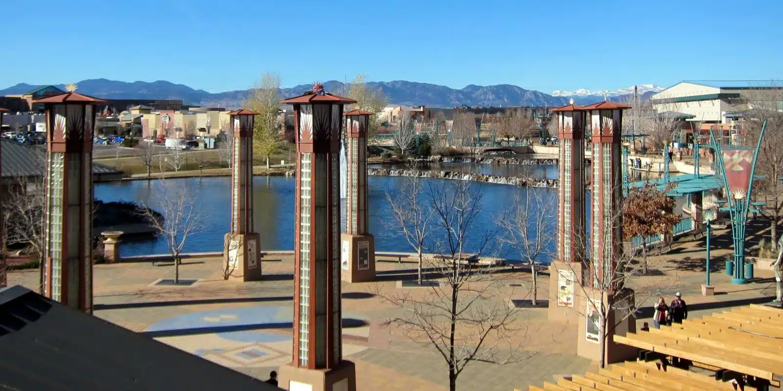 Riverside plaza with decorative towers and mountains