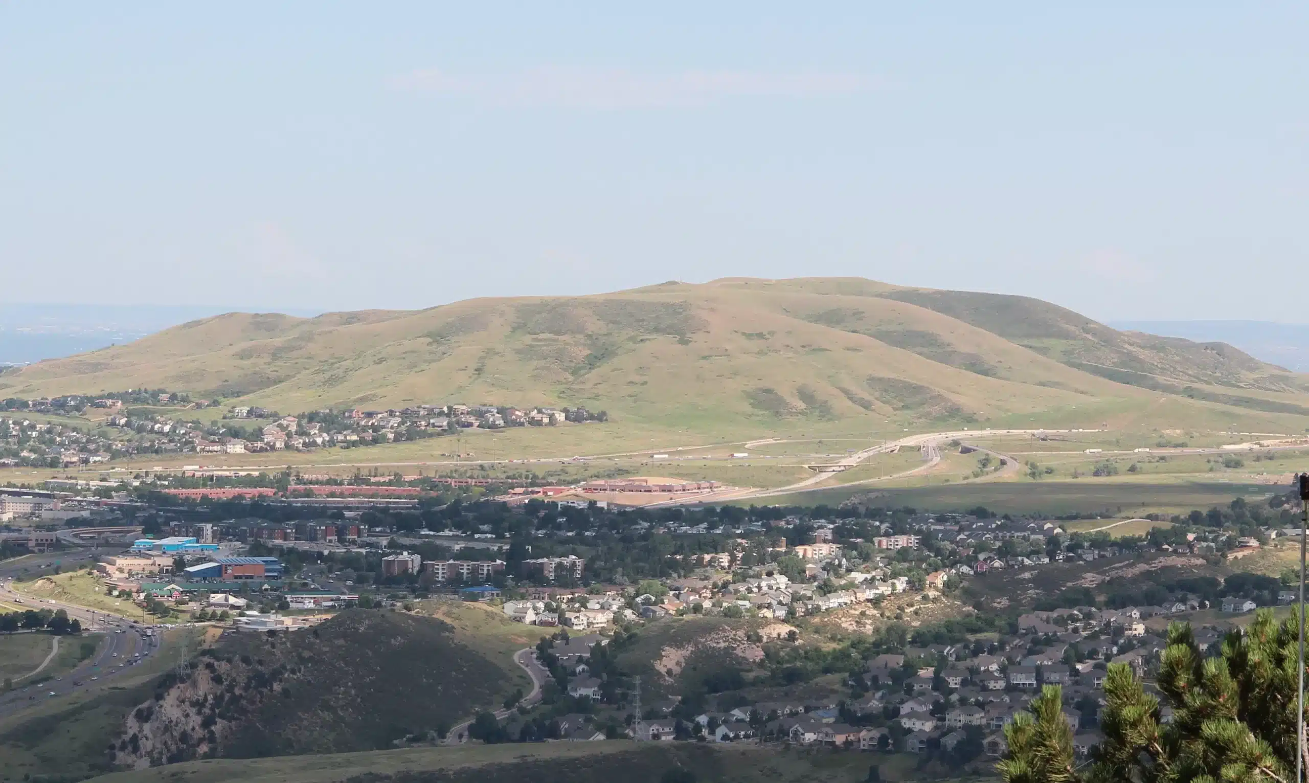 Suburban neighborhood beneath rolling green hills